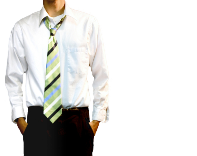 A young adult male in black pants and a white collared shirt. The green striped tie is loosened around the neck, top button is undone.