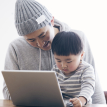Japanese man teaching how to use a pc to his son.